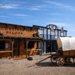 Oude westernstraat met een saloon, wagen en houten gevels.